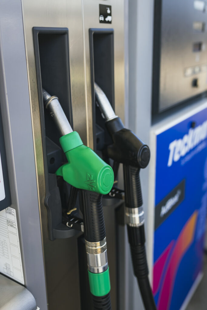 Primer plano de dos boquereles de combustible, uno verde para gasolina y otro negro para gasóleo, colocados en un surtidor de la Gasolinera Teckmar